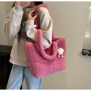 Rosa Plüsch-Einkaufstasche mit Karomuster und weißem Anhänger an der Modelschulter
