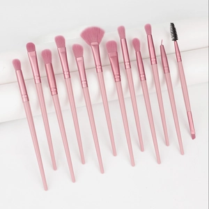 Close-up of 13 professional pink makeup brushes set including eye and face tools
