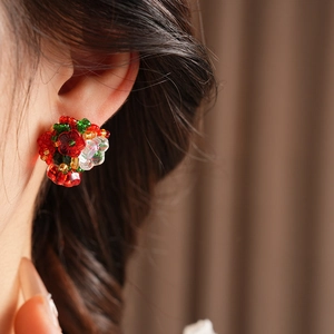 Close-up of vintage floral stud earrings with multi-color beads and crystals on a model