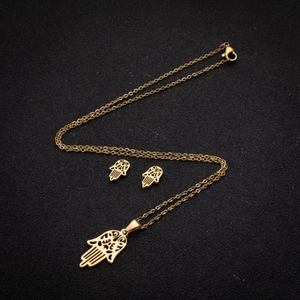 Gold Hamsa Hand jewelry set featuring hollowed pendant necklace and matching stud earrings