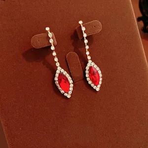 Elegant gold-tone drop earrings featuring red marquise stones and white crystal accents