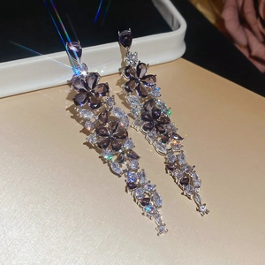 Macro view of purple gemstone flower earrings with sparkling silver diamond tassels