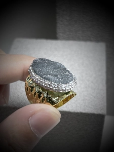 Detail shot of the dark grey crystal druzy ring with a hammered gold-tone textured band