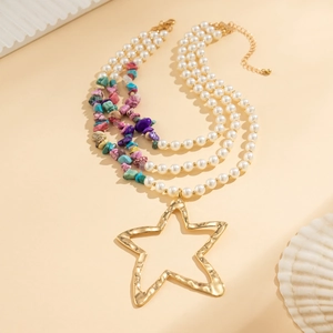 Detail of layered bohemian necklace with star pendant, pearls and colorful stone beads