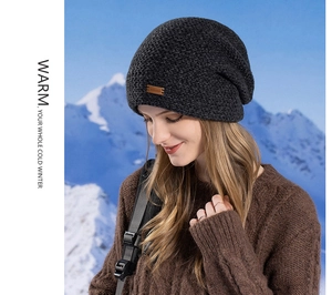 Gros plan du bonnet en tricot avec écusson en cuir sur fond de montagnes enneigées