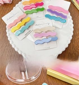 Set of wavy candy-colored acetate hair clips in various macaron shades on card