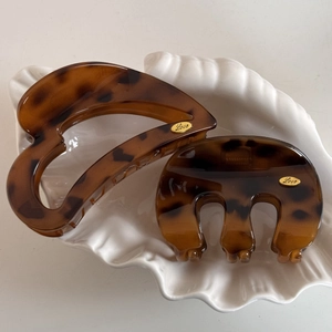 Detailed shot of tortoiseshell hair claws with gold Love engraving in a shell tray