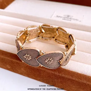 Vintage elastic heart bracelet with antique gold finish and intricate floral metal details