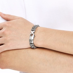 Gros plan sur bracelet gourmette rétro en argent gravé porté au poignet pour homme