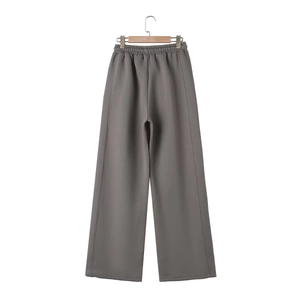 Detail of dark gray wide-leg joggers with elastic waistband on a hanger