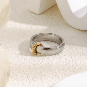 Macro d'une bague minimaliste en acier argenté avec petit cercle doré sur pierre