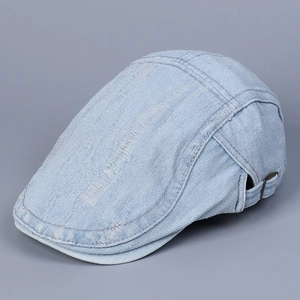 Detail of light blue washed denim flat cap with vintage distressed ripped finish and metal buckle
