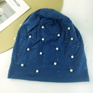 Détail du bonnet bleu orné de perles blanches et de paillettes argentées brillantes