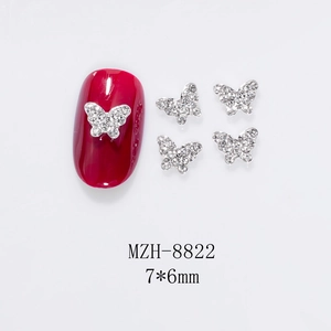 Macro view of mini 7x6mm silver hollow butterfly nail charms with white rhinestones