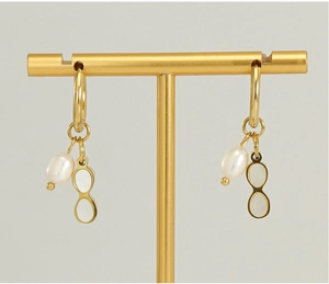 Detail of 18K gold geometric earrings with natural pearls and oval shell pendants