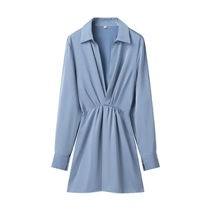 Detail of the blue satin dress showing the V-neckline, shirt collar, and pleated fabric