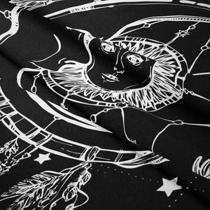 Macro shot of sun and moon print on bohemian black tapestry with soft fabric texture
