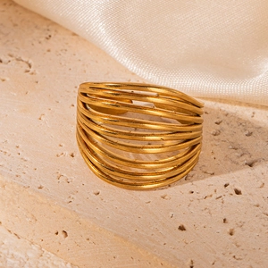 Close-up of 18K gold-plated stainless steel wide ring on a textured stone surface