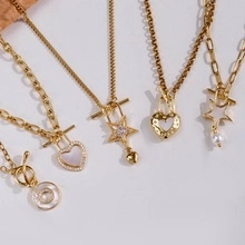 Close-up of assorted 18k gold plated titanium steel necklaces with heart and star pendants