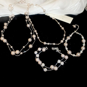 Detailed set of layered pearl necklaces and bracelets with crystal accents on velvet