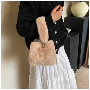 Model showing beige faux fur bucket bag with 'love every day' metal plaque on shoulder