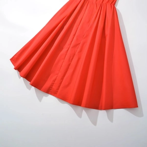 Robe mi-longue rouge vif élégante avec jupe plissée et matière lisse au style minimaliste