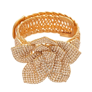Golden multi-strand wire cuff bracelet featuring a large layered flower with crystal pavé