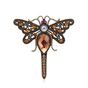 Detailed view of vintage dragonfly brooch with amber rhinestones on bronze metal base