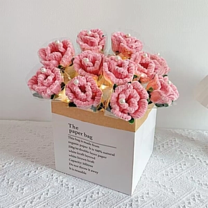 Pink plush handmade flower bouquet with warm LED string lights in a white paper gift bag