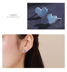Detail view of heart-shaped turquoise mosaic stud earrings on a silver needle post