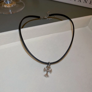 Close-up of a black faux leather choker necklace featuring a silver metal cross pendant