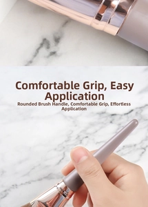 Close-up of angled foundation brush with ergonomic grey-purple handle and rose gold ferrule