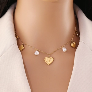 Gold layered necklace with crown heart pendant and baroque pearls on female model