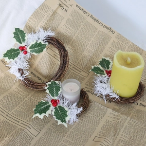 Détail d'une couronne de Noël en PVC avec baies et bougies sur papier vintage