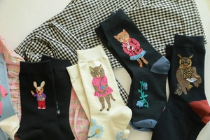Detailed view of cotton blend socks with cute animal embroidery on plaid fabric