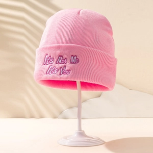 Détail du bonnet en maille rose avec broderie It's Not Me It's You en couleur violette