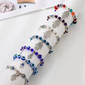 Detailweergave van kleurrijke kralenarmbanden met Hand van Fatima en Boze Oog op houder