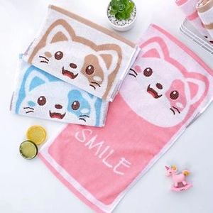 Detail of soft coral fleece towels with cute embroidered cat designs and Smile text