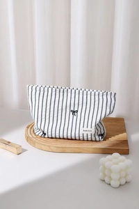 Vue détaillée de la trousse à maquillage rayée avec broderies nœuds et cordon de serrage