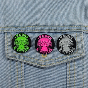 Three enamel pins with colorful gun and female silhouette designs on blue denim jacket