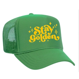 Detail shot of green mesh trucker hat featuring Stay Golden yellow art text and starry design
