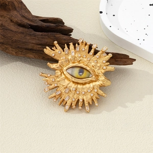 Spilla vintage dorata a forma di sole e occhio con texture a rilievo e cristalli