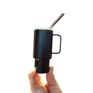 Black matte 2oz mini stainless steel tumbler with handle and straw held by fingers