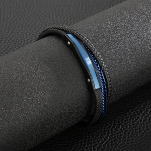 Detail of multilayer men leather bracelet with blue metal accents on a black display stand