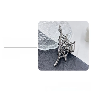 Detailed side view of gunmetal Halloween spider web metal hair claw with intricate patterns