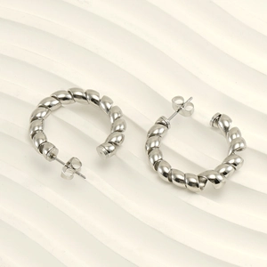 Macro view of silver twisted hoop earrings with polished stainless steel finish