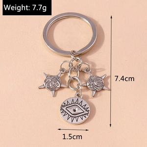 Silver metal keychain with sun stars and eye pendants showing dimensions and 7.7g weight