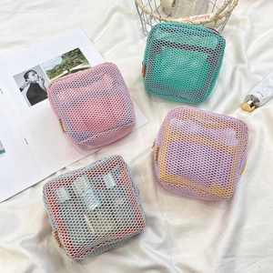 Detailed view of colorful mesh makeup pouches in pink, green, grey, and purple