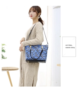 Fashionable blue snake print tote bag with black strap and golden logo detail