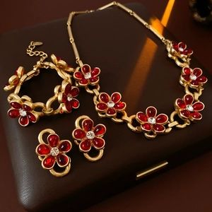 Vintage style gold jewelry set with red resin teardrop petals and sparkly rhinestones